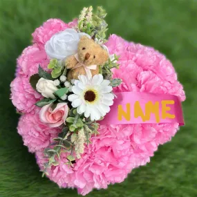 a memorial heart of artificial silk roses and carnations in shades of pink